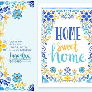 Puede incluir: Arte digital imprimible con una ilustración de acuarela de un borde floral azul y amarillo con el texto "HOME sweet home" en el centro. La obra de arte está disponible en dos tamaños: 11x8,5 pulgadas y 11x17 pulgadas.
