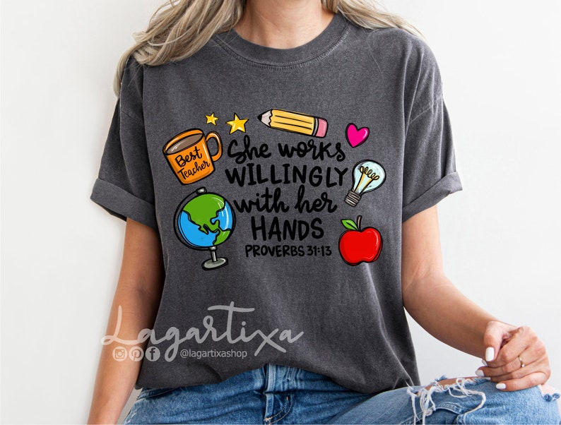 May include: A dark gray t-shirt with a graphic design featuring a coffee cup, globe, pencil, lightbulb, apple, and the text "She works willingly with her hands Proverbs 31:13".