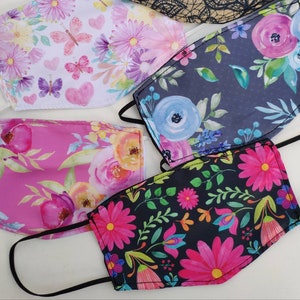 May include: Four different fabric face masks with floral patterns. The masks are all in different colors and have different floral designs. The masks are all made of a soft, breathable fabric.