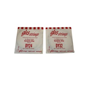 May include: Two packages of GHS strings for electric guitars. The packages are white with red and black text. One package is labeled DY24, .024" diameter, and the other is DY32, .032" diameter. The text "Dynamite Alloy" is visible.