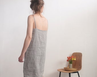 May include: A knee-length slip dress featuring a fine horizontal grey and white stripe pattern, thin spaghetti straps, and a straight neckline. The garment has a relaxed, straight-cut silhouette that falls to the knees with a simple hemline.