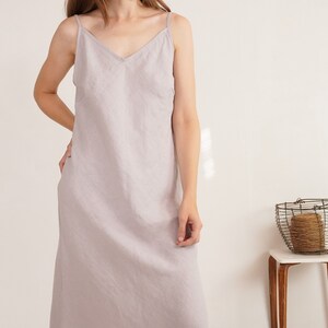 Puede incluir: Un vestido tipo lencero de color gris claro hasta los tobillos, con escote en V y tirantes finos. La prenda est&aacute; confeccionada con una tela texturizada de color s&oacute;lido que cae en una silueta recta y relajada desde los hombros al dobladillo.