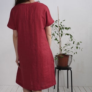 Peut inclure: Une robe en lin simple, &agrave; manches courtes, de couleur bordeaux avec un col rond.