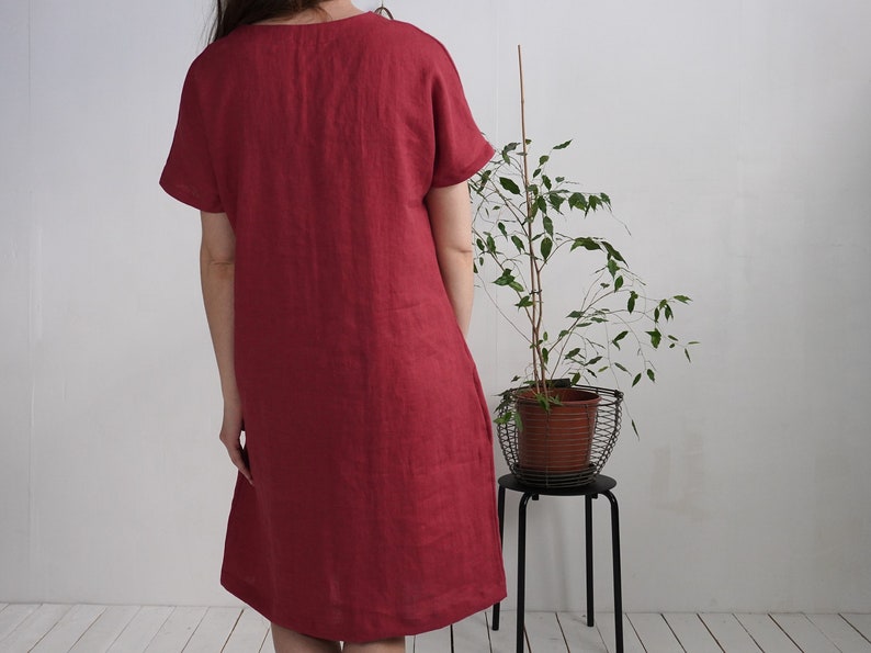 Peut inclure: Une robe en lin simple, &agrave; manches courtes, de couleur bordeaux avec un col rond.