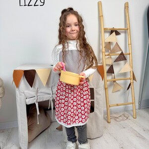 Personalized kids apron on a child while playing at the pretend kitchen