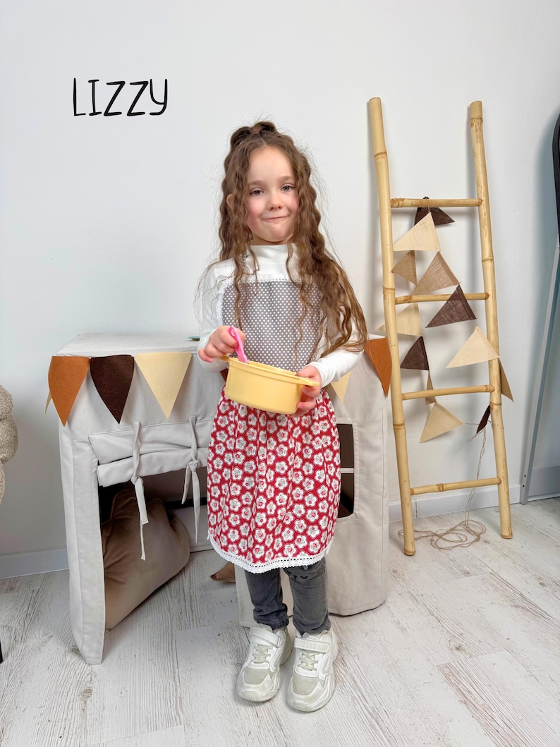 Personalized kids apron on a child while playing at the pretend kitchen