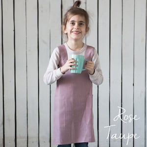 A girl modeling a linen crossover apron, showcasing its comfy and functional design.