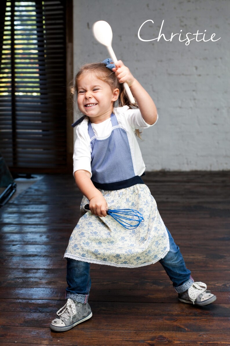 Girl in denim-blue apron mixing dough, children’s personalized art apron.