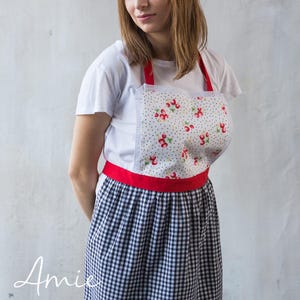 Girl in black gingham apron with red waistband, kids craft and art apron.
