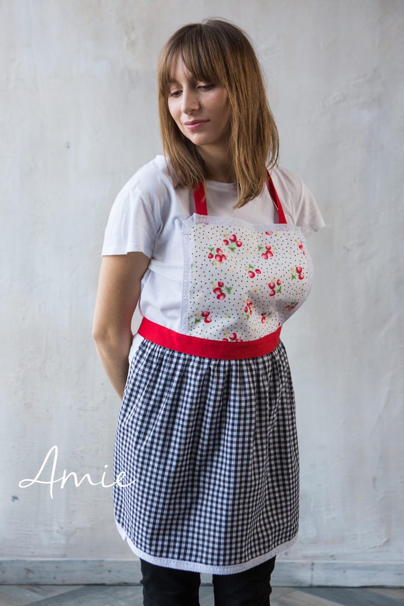 Girl in black gingham apron with red waistband, kids craft and art apron.