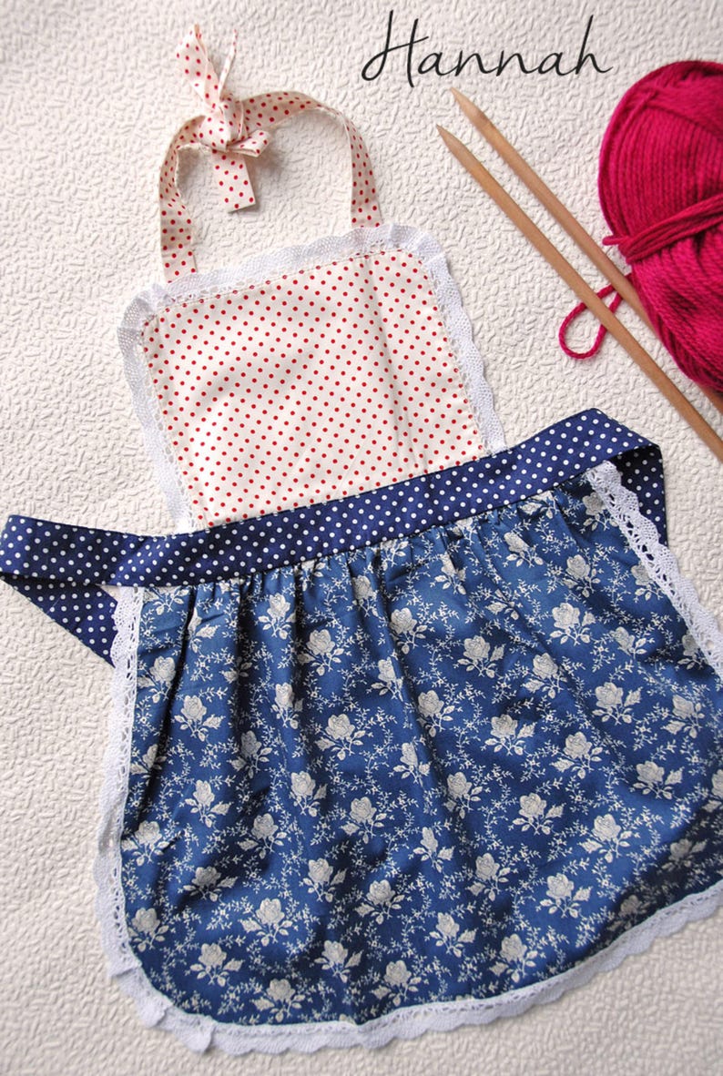 Details of cute handmade kitchen apron for girls in red polka dot and blue floral retro cotton.