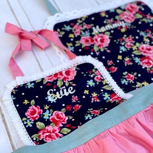 Cute pink and floral matching mother daughter aprons personalized with name embroidery.