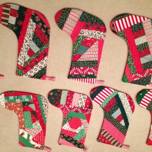 May include: Nine red and green patchwork Christmas stockings with a variety of patterns and fabrics.