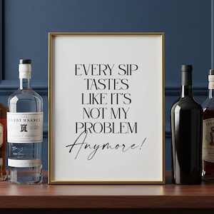 Könnte beinhalten: Ein gerahmter Druck mit dem Text "EVERY SIP TASTES LIKE IT'S NOT MY PROBLEM Anymore!". Flankiert wird er von Flaschen mit Spirituosen und Wein. Der Rahmen ist goldfarben, der Hintergrund dunkelblau.