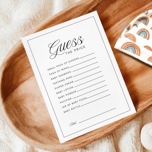 Könnte beinhalten: Eine druckbare Babyparty-Spielkarte mit dem Titel "Schätze den Preis" und einer Liste von Babyartikeln, deren Preis erraten werden soll, darunter eine kleine Packung Windeln, eine Packung Feuchttücher, Babyshampoo, ein Beißring, Wundcreme, Babylotion, Babypuder, ein Schnuller, ein Glas Babynahrung und eine Babyflasche.