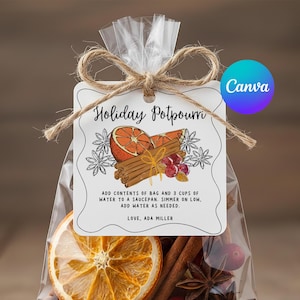 May include: A clear cellophane bag tied with twine, containing a holiday potpourri mix. The tag reads "Holiday Potpourri" with instructions and a signature. The mix includes dried orange slices, cinnamon sticks, and star anise.
