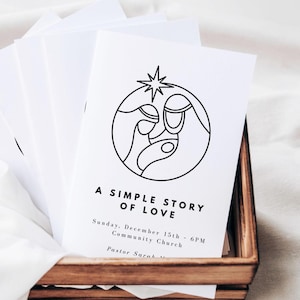 Pode incluir: Cartões brancos com um desenho a traço preto de uma cena de natividade, uma estrela e o texto "A Simple Story of Love". Os cartões estão numa bandeja de madeira. O texto também inclui a data e hora de um evento.