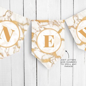 May include: A gold and white marble banner with the word "NEW" in gold letters. The banner is strung on a white wooden background. Edit letters and numbers to spell any phrase.