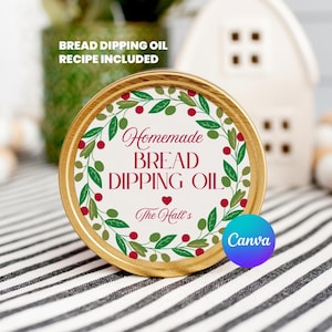 May include: A jar lid with a gold rim and a label that reads "Homemade Bread Dipping Oil." The label features a wreath of green leaves and red berries. The text "Bread Dipping Oil Recipe Included" is also visible.
