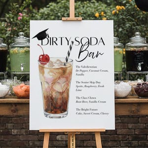 May include: A white sign on an easel with the words "DIRTY SODA Bar" and a graduation cap illustration. The sign lists soda drink recipes, including "The Valedictorian" and "The Bright Future." A glass of soda with a cherry and straw is pictured.