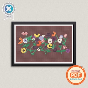 Puede incluir: Un diseño floral en punto de cruz enmarcado con una variedad de flores coloridas y vides verdes sobre un fondo marrón. La obra de arte está en un marco negro e incluye una insignia "Tested" y un gráfico de "Descarga instantánea en PDF".