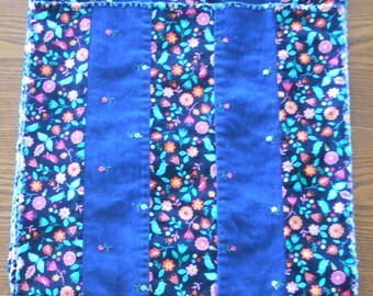 May include: Set of six blue and floral fabric placemats. Each placemat has three blue stripes and two floral stripes. The floral fabric features a black background with colorful flowers and birds.
