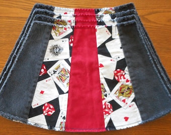 May include: Set of six black denim placemats with a red and white fabric center featuring a repeating pattern of playing cards and dice.