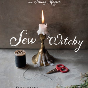 May include: A book cover with the title "Sew Witchy" and the author's name, Raechel Henderson. The image features a lit candle in a brass holder, a spool of black thread, and small red scissors. The book's subtitle reads "Tools, Techniques & Projects for Sewing Magick."