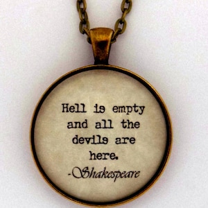 May include: A gold necklace with a round pendant featuring a white background and black text that reads "Hell is empty and all the devils are here. -Shakespeare".
