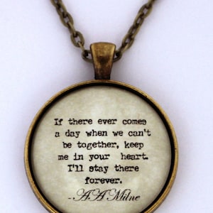 May include: A gold necklace with a round pendant featuring a quote by A.A. Milne: "If there ever comes a day when we can't be together, keep me in your heart. I'll stay there forever."