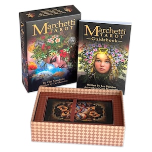 May include: A boxed set of the Marchetti Tarot deck, featuring a guidebook and a deck of cards with colorful illustrations. The box is brown with a checkered pattern and the guidebook has a black cover with gold lettering.