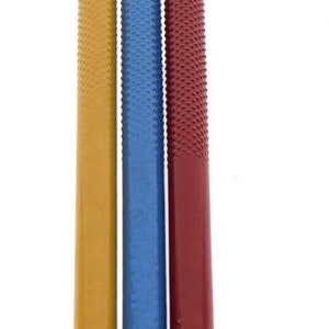 May include: Three metal tools with pointed tips and colored handles. The handles are yellow, blue, and red.