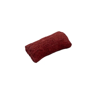 May include: A dark red, textured, rectangular sponge. The sponge is made of a porous material and has a rough surface.