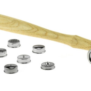 May include: A silver metal hammer with a wooden handle and a set of interchangeable heads. The heads are silver metal and have different textures and shapes.