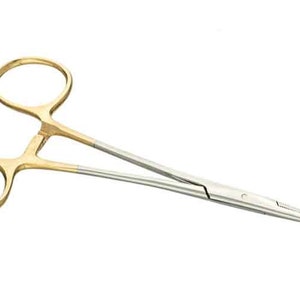 May include: Gold-toned surgical clamps with a silver blade. The clamps are closed and have a rounded tip.