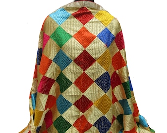 May include: A colorful patterned shawl with a gold background. The shawl is made of a soft fabric and features a diamond pattern with various colors, including red, blue, green, yellow, and orange.