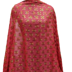 May include: A red scarf with a floral pattern. The scarf is made of a sheer fabric and is decorated with gold and green embroidered flowers. The scarf is draped over a mannequin, showcasing its design and texture.