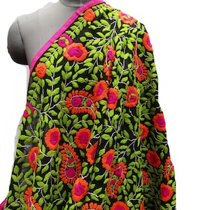 Könnte beinhalten: Ein schwarzer Schal mit dichter Stickerei aus leuchtend lindgrünen Blättern sowie kräftigen orangefarbenen und pinken Blumen- und Paisley-Motiven. Der Stoff ist an der Kante mit einem einfarbigen pinken Saum versehen, was für Kontrast sorgt.