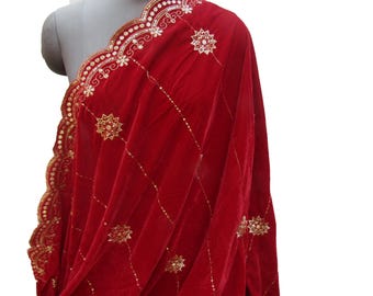 May include: A draped red velvet shawl with gold embellishments. The shawl features a scalloped edge with gold sequins and floral designs. Gold star-shaped embroidery is scattered across the fabric, creating a luxurious look.