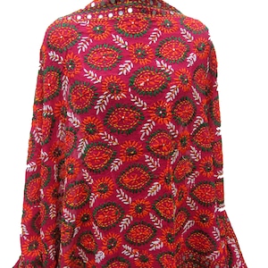 Peut inclure: Un châle rouge, vert et blanc brodé avec un motif floral. Le châle est décoré de petits miroirs.