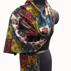 May include: A colorful patchwork scarf with a variety of floral and geometric patterns in shades of red, blue, yellow, and black.