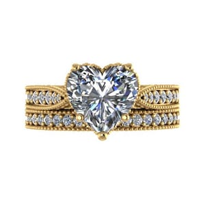 May include: A gold heart-shaped diamond engagement ring with a matching band. The ring is set with small diamonds around the band.
