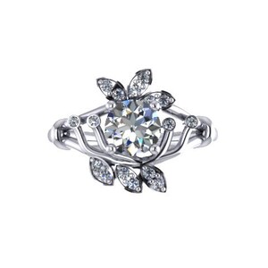 May include: A silver engagement ring with a large, round, clear gemstone at the center. The ring features a floral design with smaller gemstones and leaf-like accents. The band has a delicate, interwoven pattern.