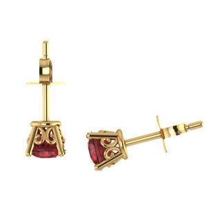 May include: A pair of gold earrings with a red gemstone set in a decorative filigree design.