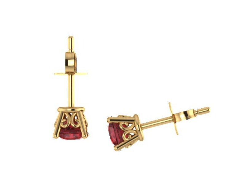 May include: A pair of gold earrings with a red gemstone set in a decorative filigree design.