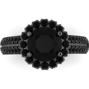 May include: A black ring with a large, round center stone surrounded by smaller stones. The band has a textured design. The ring is set against a white background.