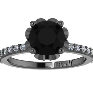 May include: Black engagement ring with a large black diamond center stone and a band of smaller white diamonds. The ring is set in black metal and has the inscription "JA*V" on the band.