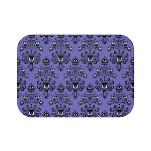 May include: Purple bath mat with a black and white repeating pattern of a haunted house with ghosts and owls.