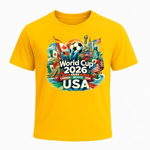 Puede incluir: Una camiseta amarilla con un dise&ntilde;o gr&aacute;fico colorido para la Copa Mundial de 2026, organizada por Canad&aacute;, M&eacute;xico y EE. UU. El dise&ntilde;o incluye un bal&oacute;n de f&uacute;tbol, banderas y monumentos.