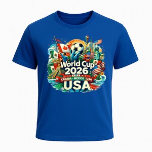 Puede incluir: Una camiseta azul real con un gr&aacute;fico colorido para la Copa del Mundo 2026, organizada por Canad&aacute;, M&eacute;xico y EE. UU. El dise&ntilde;o incluye un bal&oacute;n de f&uacute;tbol, banderas y monumentos.